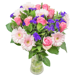Arranged with the gentle artistry that defines Lisson Grove, this bouquet is an ode to life's luminous moments. The interplay between tender pink gerbera daisies and blushing roses conjures an image of morning light filtering through Marylebone's leafy streets. The harmonious union of soft pinks is elevated by sprightly tufts of royal purple statice, which peek playfully among the blooms, adding depth and a pop of vibrant color reminiscent of the blooms lining Regent's Canal in spring. Stems of verdant foliage provide a dewy, forest-green backdrop, their cool freshness anchoring the cheerful arrangement above. Encased within an understated glass vase, the composition glows as though illuminated by the soft afternoon sun that often gilds Lisson Grove's historical crescents. Each floral choice reflects not only beauty but resilience-a bouquet that brings lightness and optimism, ideal for congratulating a neighbor on a new home near St. John's Wood or brightening a loved one's recovery. The overall feel is modern yet timeless: an expertly crafted celebration of joy, hope, and community that echoes the welcoming atmosphere of Lisson Grove itself.